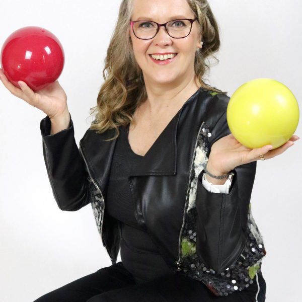 nainen istuu lattialla pallot kädessä